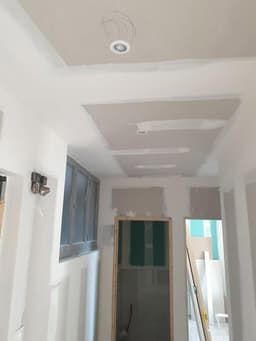 Couloir avec faux plafond, spots et doublages repris avant peinture