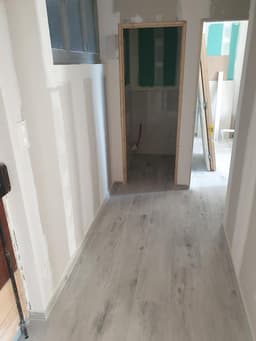 Couloir rénové avec sol clair et doublages prêts pour finition