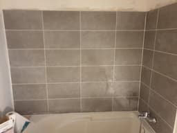 Salle d'eau carrelée avec niches de rangement et réservations sanitaires