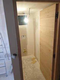 Passage étroit rénové avec porte bois et sol en cours de protection