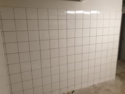 Alignement de carreaux blancs sur support mural remis à niveau