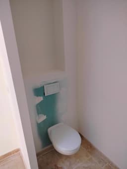 WC rénové avec bâti encastré et raccords de finition autour du sol