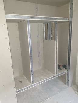 Structure de dressing sur mesure avec rails, montants et cloisons en cours de montage