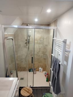 Salle de bains terminée avec douche à l'italienne, paroi vitrée et carrelage décoratif au fond