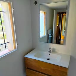 Rénovation salle de bain : meuble vasque bois clair, plan vasque céramique blanc, mitigeur chrome et miroir rectangulaire