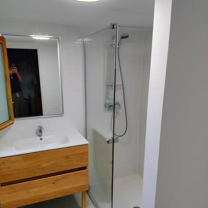 Salle de bain : angle meuble vasque bois suspendu, vasque intégrée, miroir et cabine douche vitrée chromée