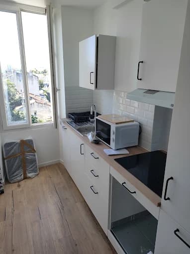 Cuisine linéaire blanche, crédence métro, plan bois et fenêtre