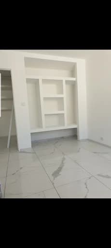 Niches et étagères intégrées blanches, sol carrelage effet marbre