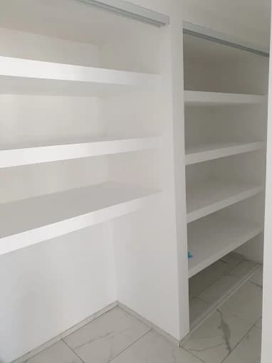 Placard sur mesure blanc, étagères et rails portes coulissantes, sol marbre