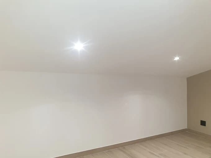 Chambre mansardée : murs blanc et taupe, sol aspect bois