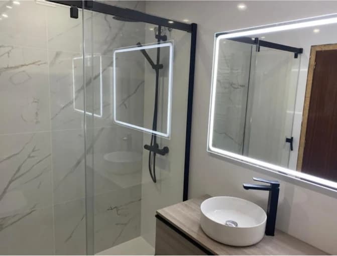 Salle de bain : marbre blanc, douche noir mat, vasque bois, miroir LED
