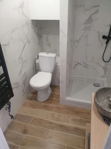 Sanitaires : vasque, WC et faïence claire type marbre, sol carrelé