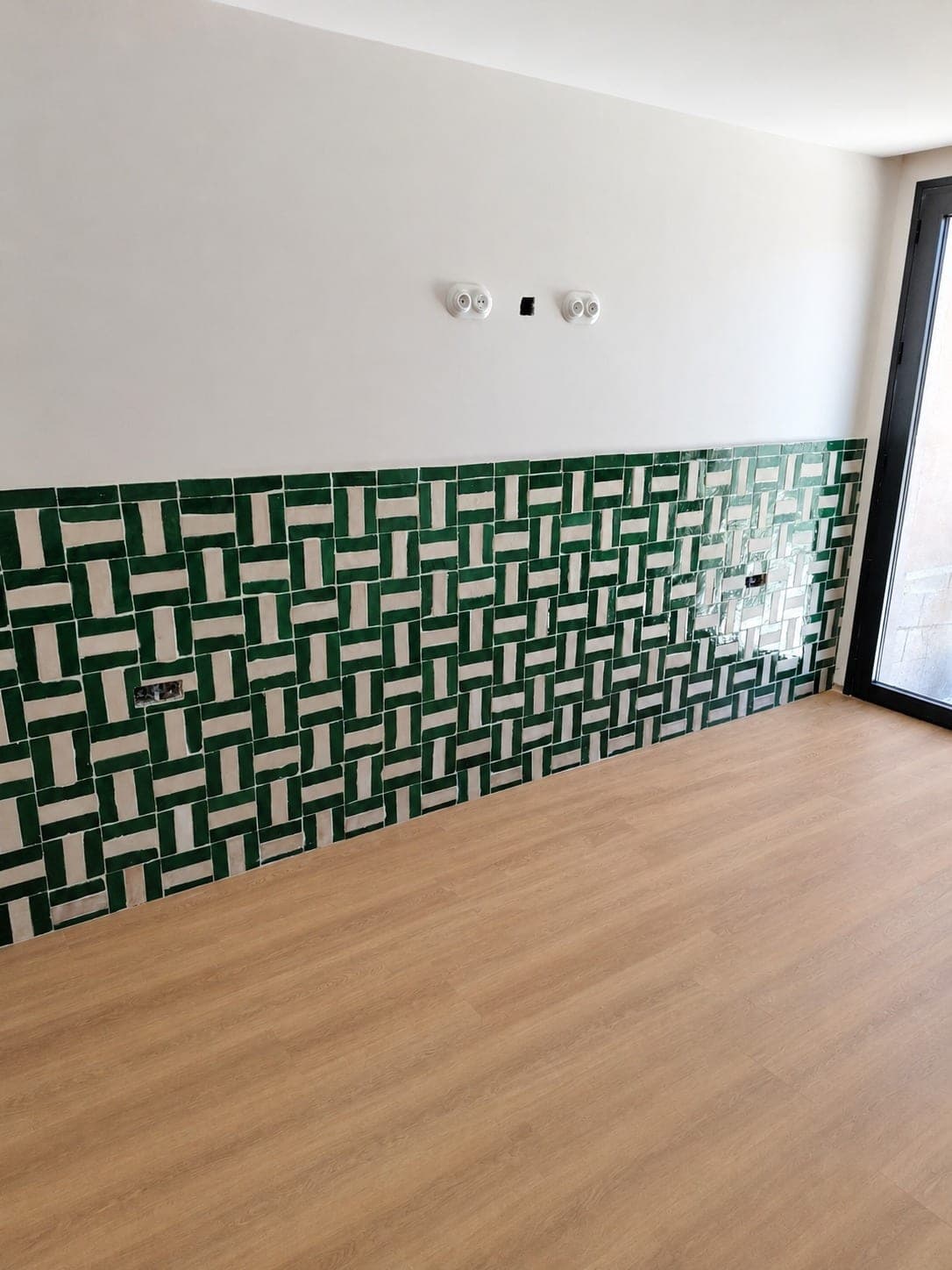 Mur décoratif vert et blanc posé en soubassement.