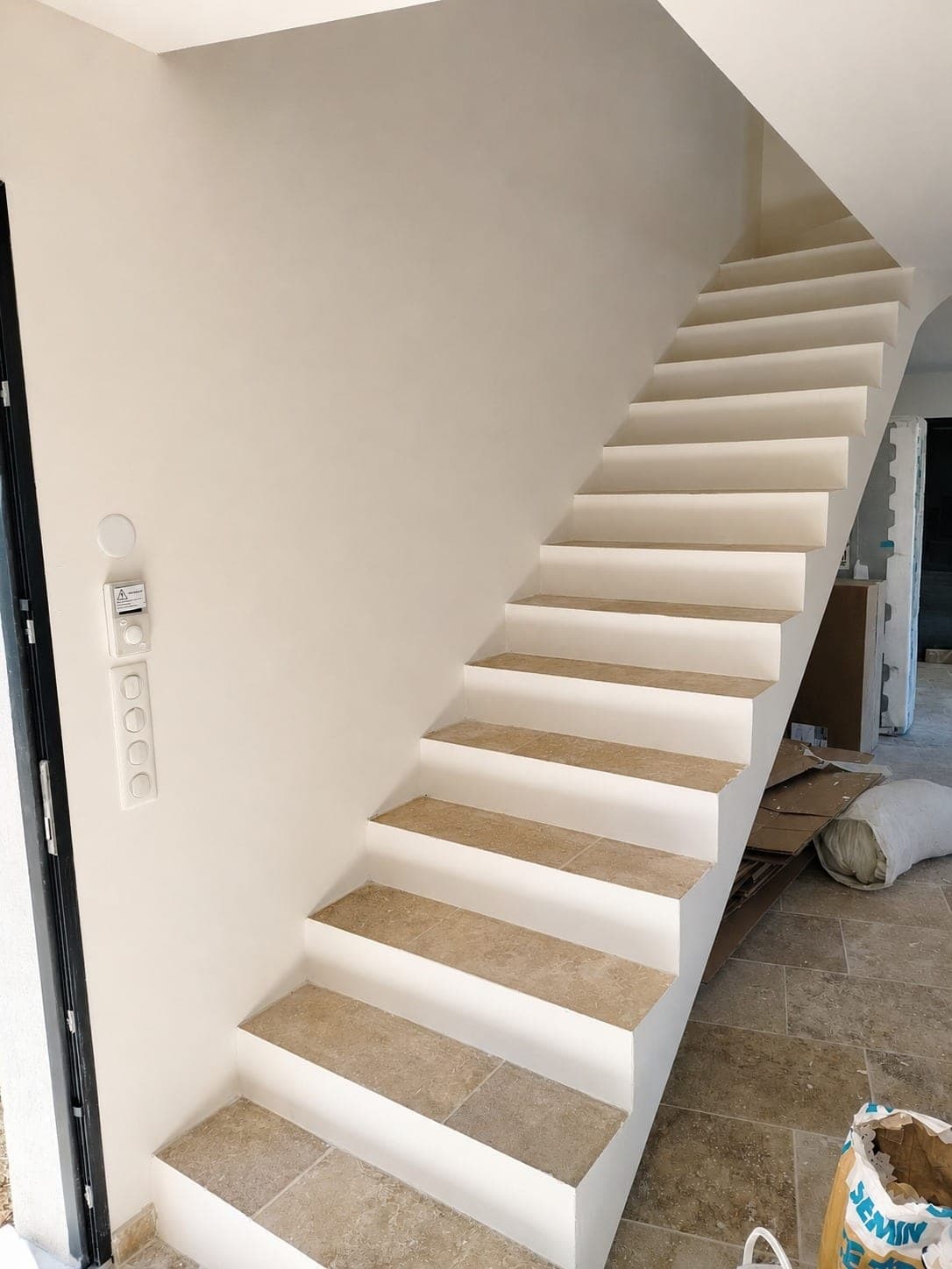Escalier et murs blancs ; le carrelage n'est pas le sujet principal.