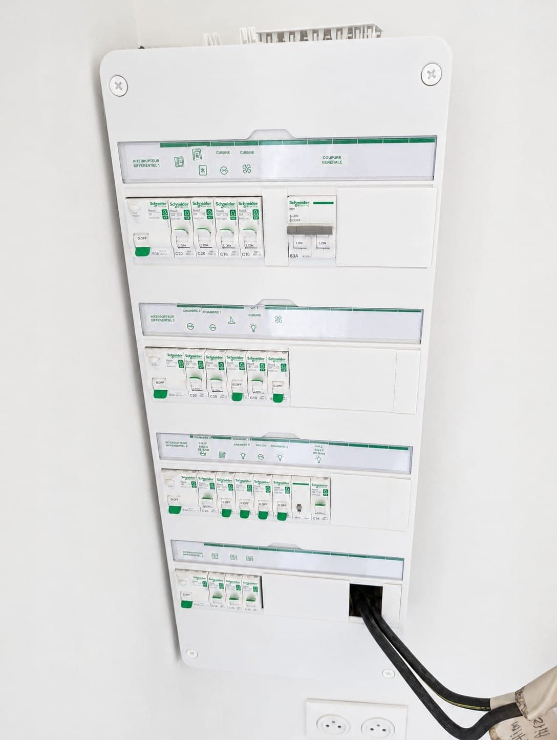 Tableau Schneider apparent avec plusieurs rangées de protections.