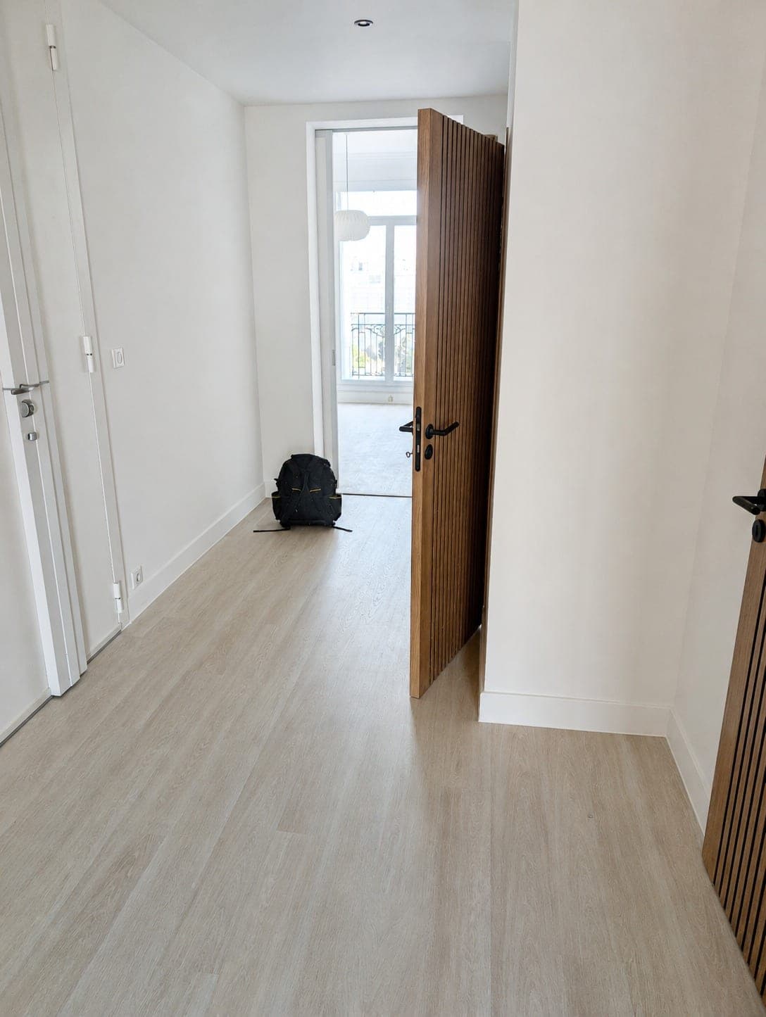 Couloir ou dégagement avec revêtement bois clair.