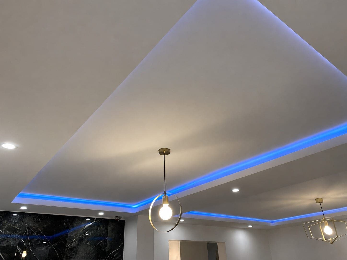 Plafond décaissé avec éclairage LED et spots.