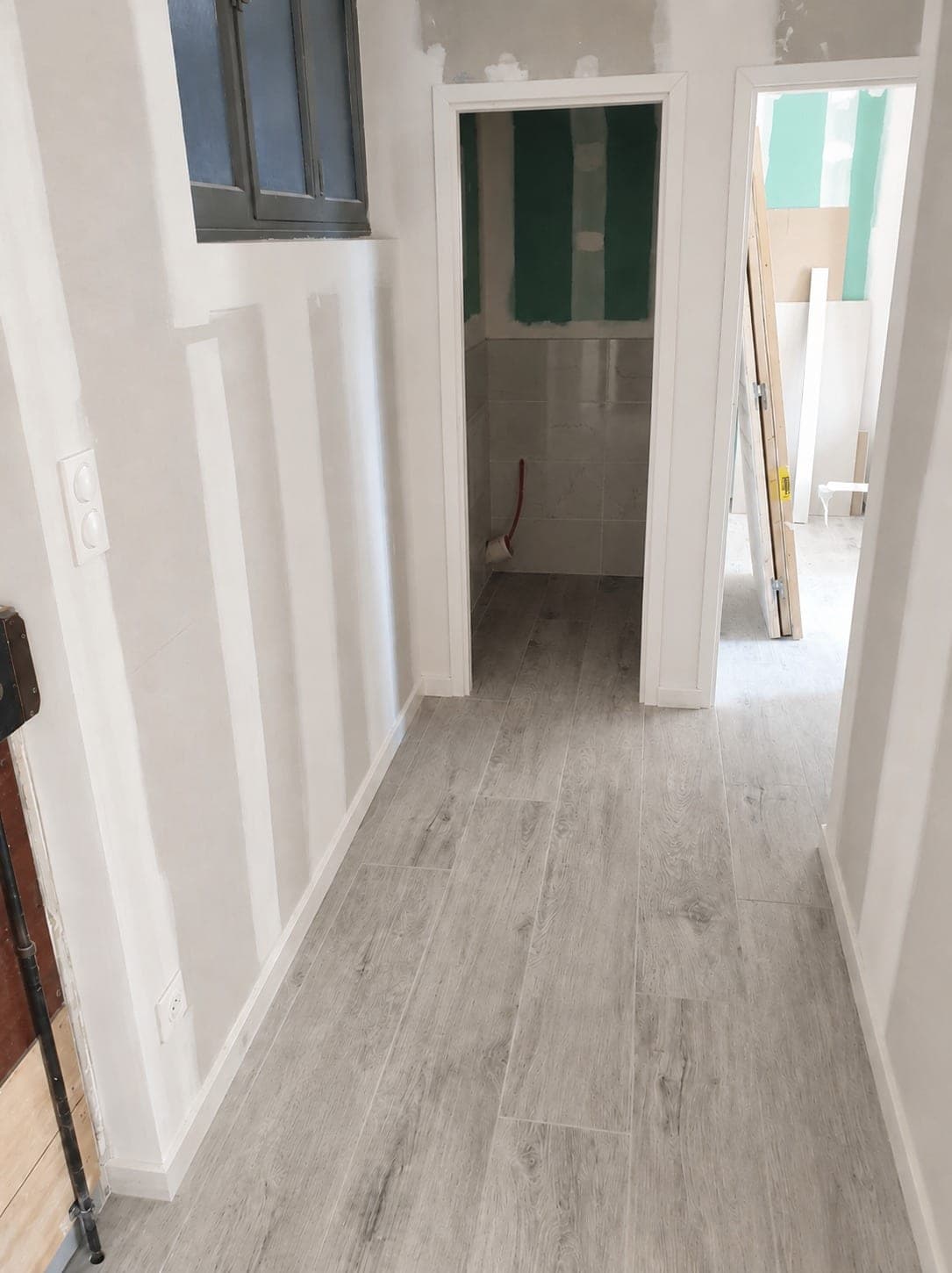 Couloir avec contre-cloisons et accès à une pièce d'eau en cours.