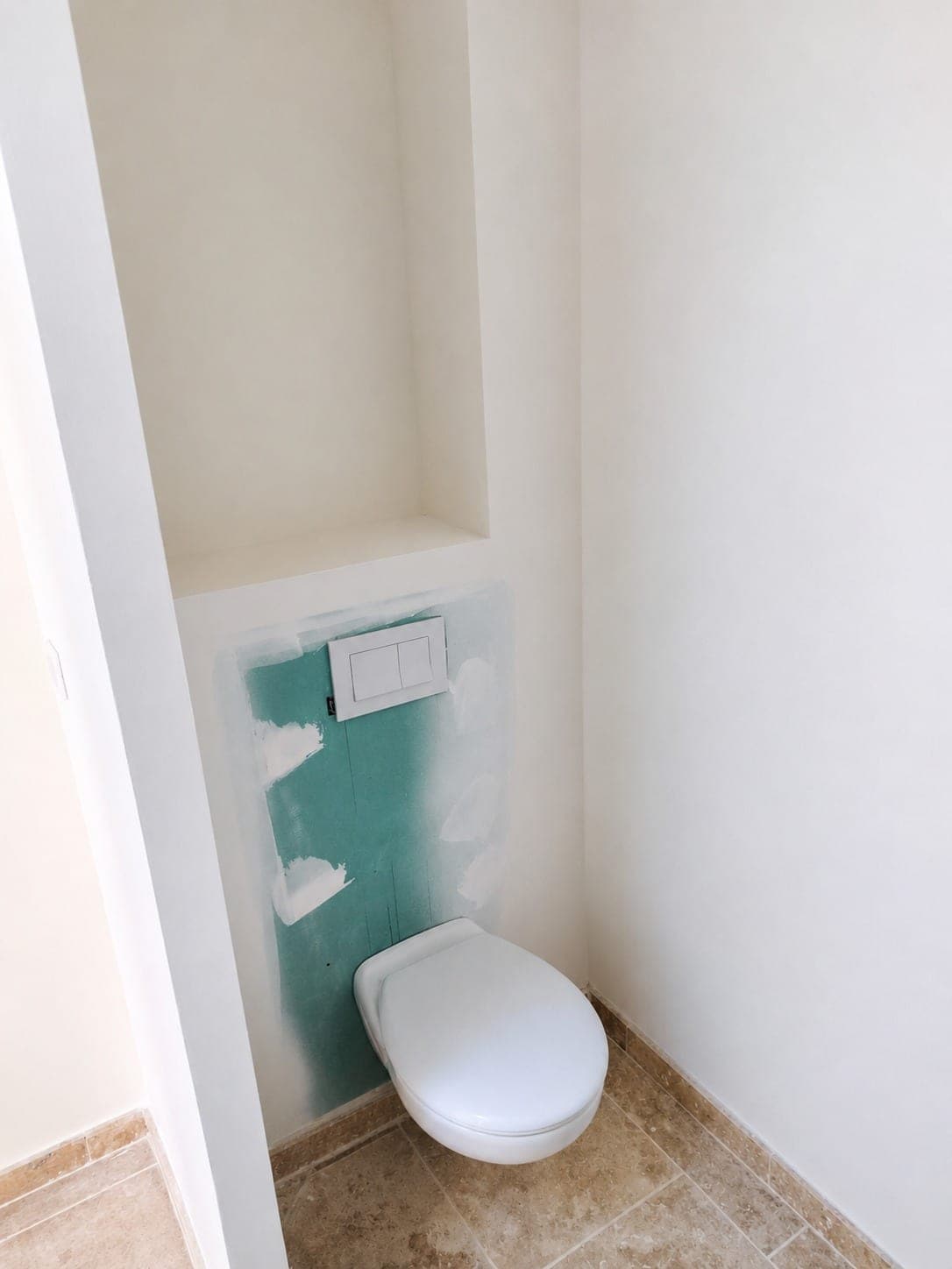 WC suspendu en phase de finition avec bâti et plaque de commande.