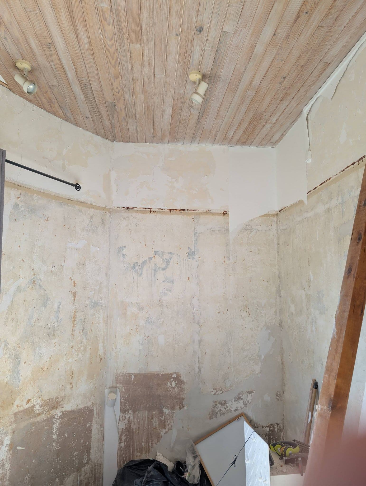 Volume intérieur en rénovation avec plafond habillé, murs décapés et zone technique encore à reprendre