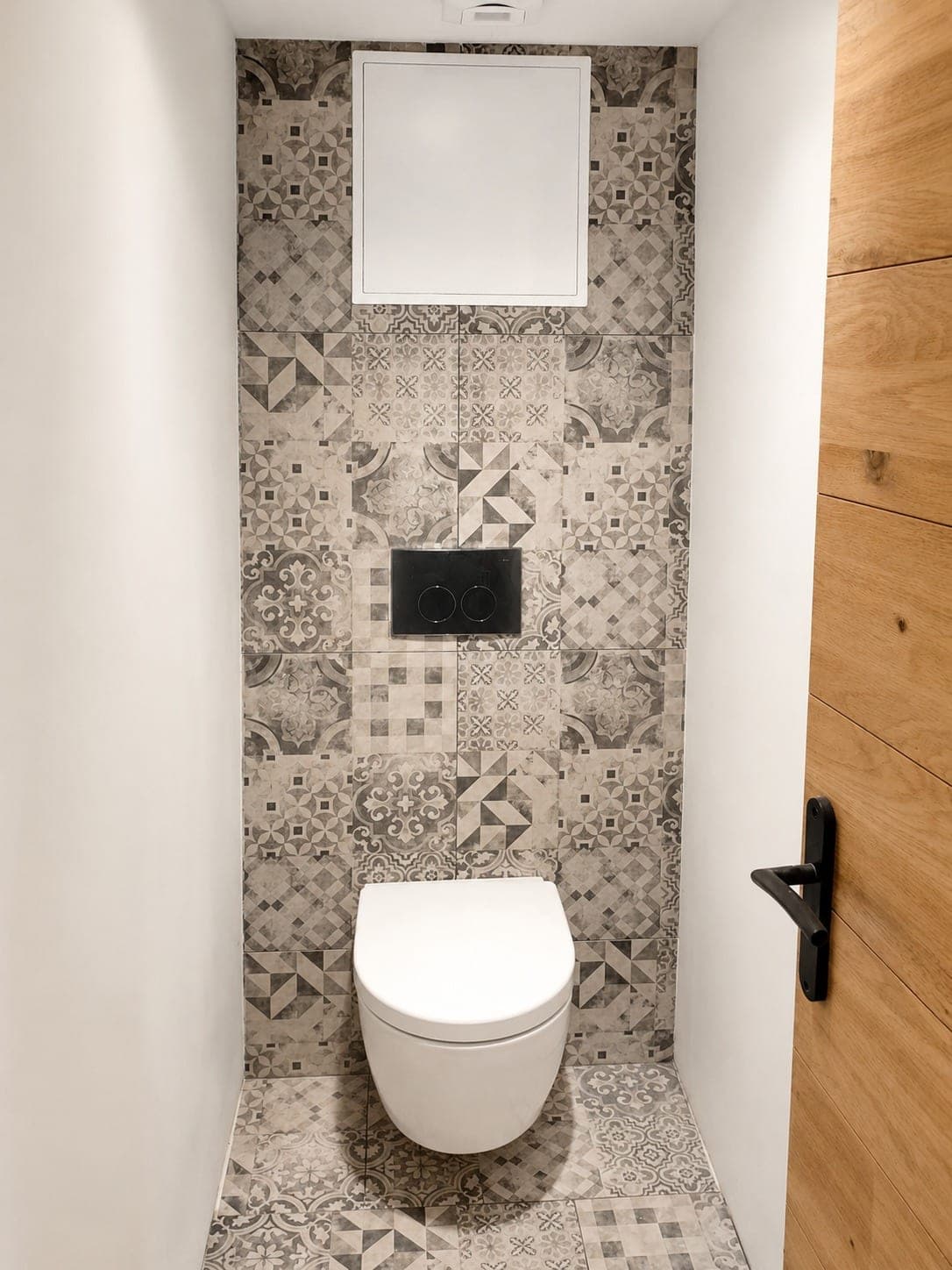 WC suspendu avec bâti intégré et carrelage décoratif.